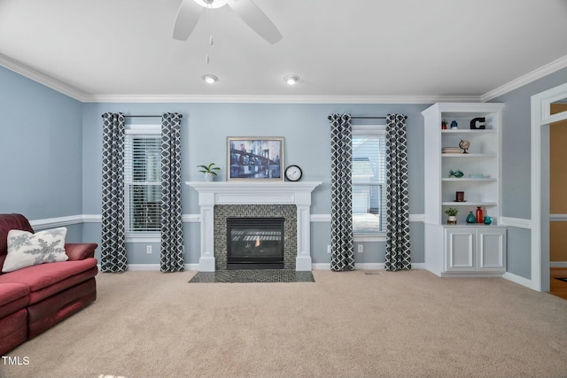 living room with light carpet, a tiled fireplace, baseboards, and crown molding