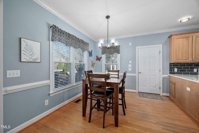 dining space with light wood-style floors, visible vents, ornamental molding, and baseboards