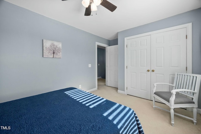 bedroom with a closet, light carpet, ceiling fan, and baseboards