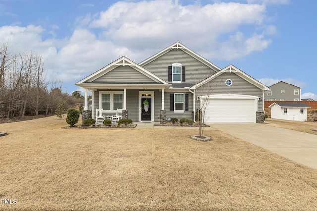 craftsman inspired home featuring a garage, a porch, concrete driveway, and a front yard