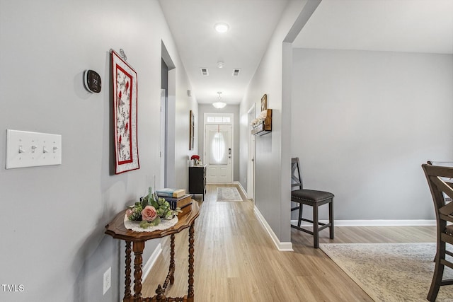 hallway featuring light wood-type flooring and baseboards