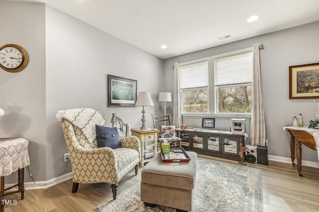 living area featuring recessed lighting, visible vents, baseboards, and wood finished floors