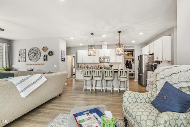 living area with light wood-style floors and recessed lighting