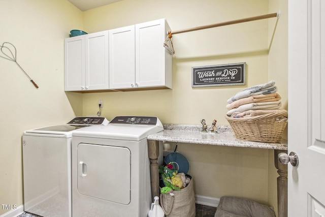 clothes washing area with cabinet space and washer and clothes dryer