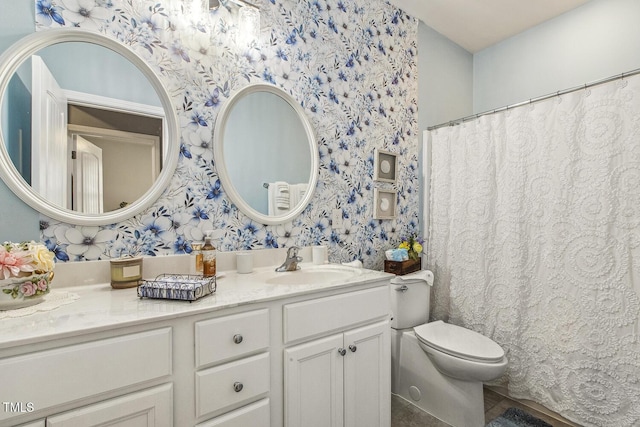 bathroom featuring vanity, toilet, and wallpapered walls