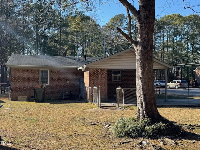 exterior space with brick siding, fence, and a lawn