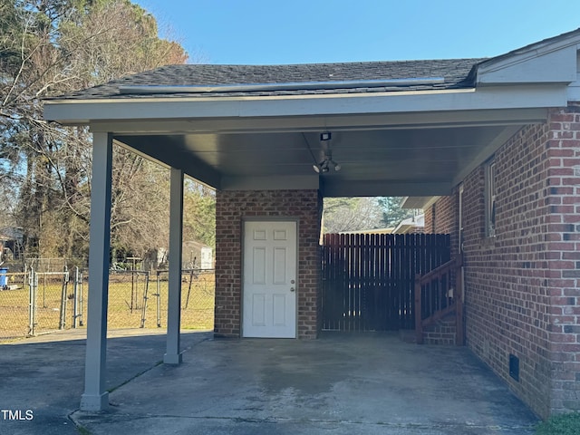 view of patio / terrace with an attached carport, a gate, fence, and driveway