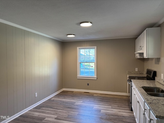 kitchen featuring under cabinet range hood, light stone countertops, stainless steel electric range, and white cabinetry