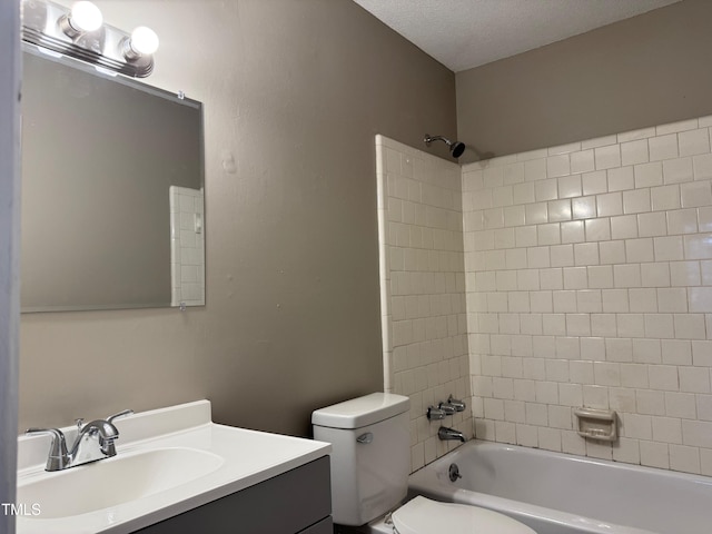 full bath featuring  shower combination, toilet, vanity, and a textured ceiling