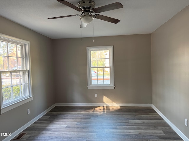 unfurnished room featuring visible vents, a wealth of natural light, and baseboards