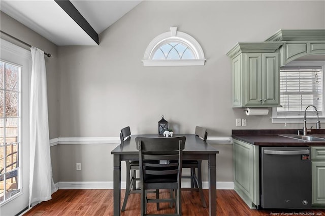 interior space featuring dark countertops, green cabinets, a sink, and stainless steel dishwasher