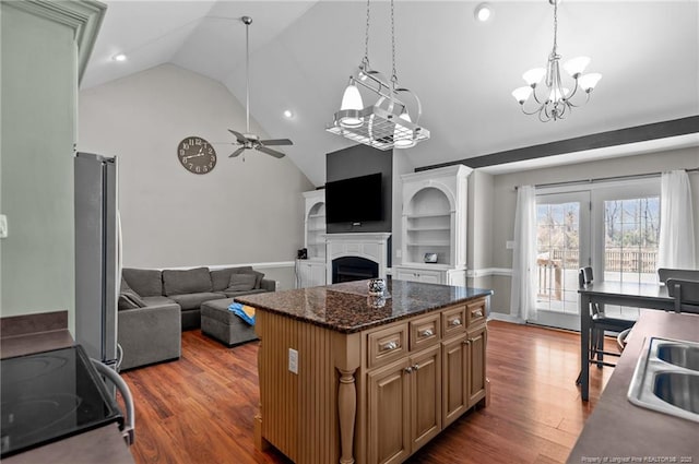 kitchen with pendant lighting, dark wood finished floors, stainless steel appliances, open floor plan, and a kitchen island