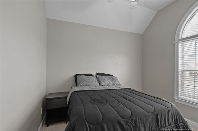 bedroom featuring a ceiling fan, lofted ceiling, light colored carpet, and baseboards