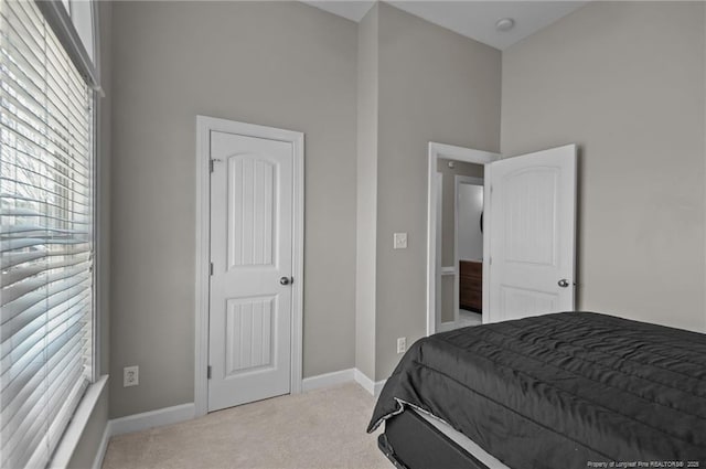 bedroom with light carpet and baseboards