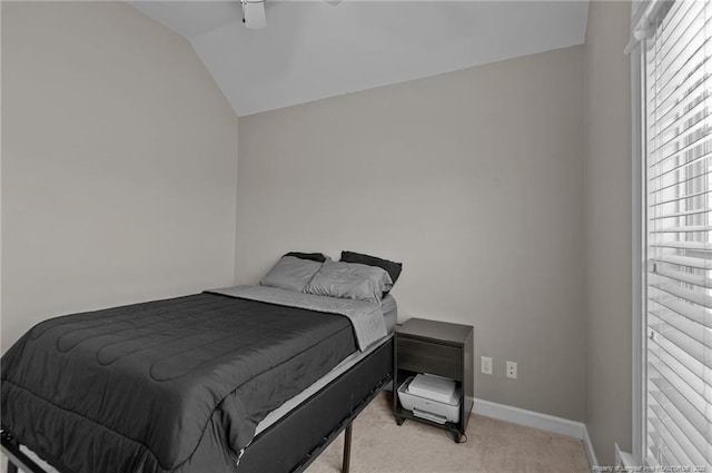 bedroom with lofted ceiling, light colored carpet, and baseboards