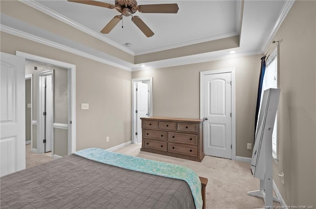 bedroom with ceiling fan, light carpet, baseboards, ornamental molding, and a tray ceiling