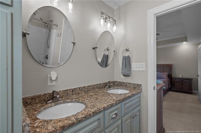 bathroom featuring ensuite bathroom, double vanity, a sink, and crown molding