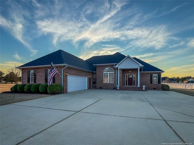 single story home featuring crawl space, brick siding, driveway, and an attached garage