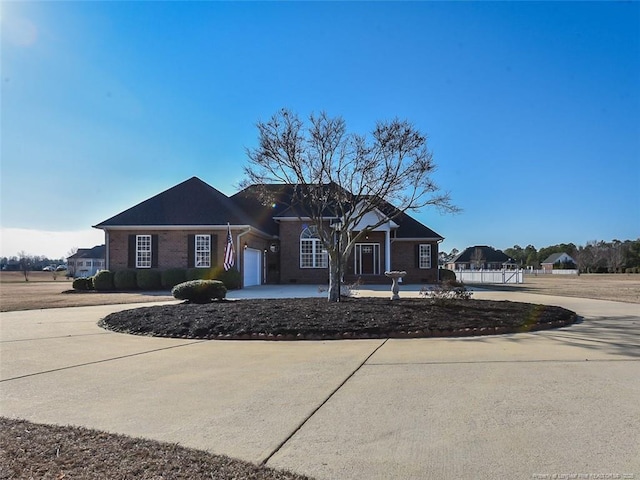 view of front of house with concrete driveway, brick siding, and an attached garage