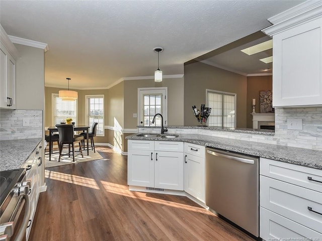 kitchen featuring stainless steel appliances, white cabinetry, a sink, and light stone counters