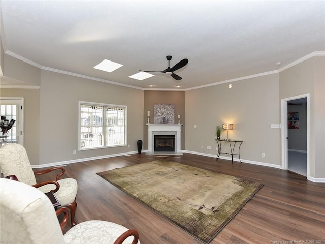 living area featuring crown molding, a fireplace, baseboards, and dark wood-type flooring