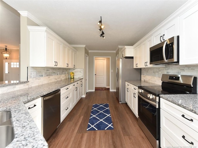 kitchen with dark wood finished floors, crown molding, stainless steel appliances, white cabinetry, and light stone countertops