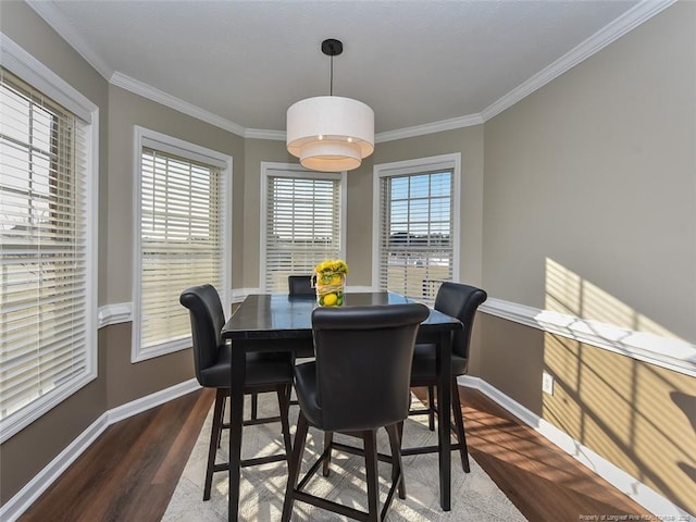 dining space with dark wood-style floors, baseboards, and crown molding