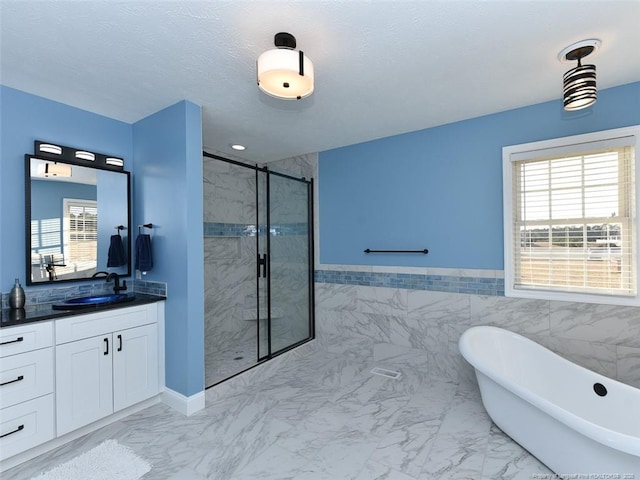 full bath with a textured ceiling, vanity, marble finish floor, a soaking tub, and a stall shower