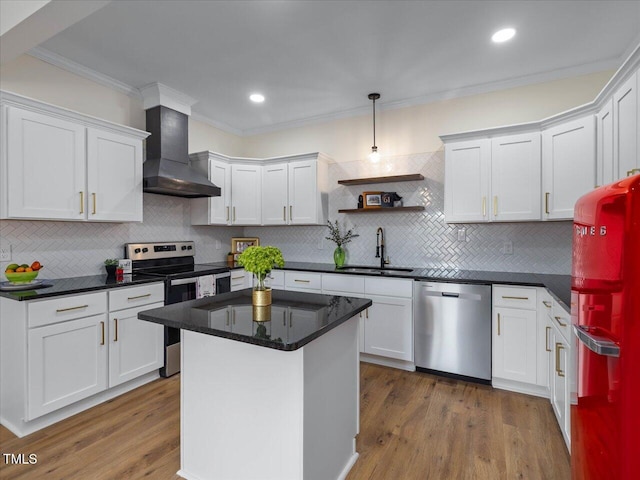 kitchen featuring stainless steel appliances, white cabinets, a sink, and wall chimney range hood