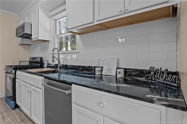 kitchen with tasteful backsplash, white cabinetry, stainless steel appliances, and dark stone counters