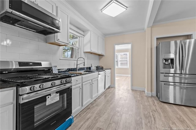 kitchen featuring appliances with stainless steel finishes, white cabinetry, and extractor fan