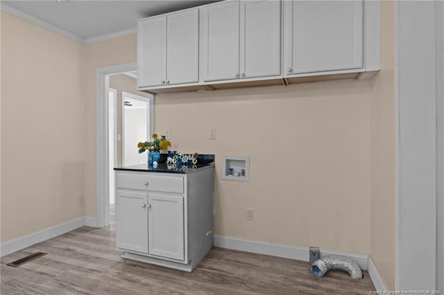 laundry area with light wood finished floors, cabinet space, baseboards, visible vents, and washer hookup