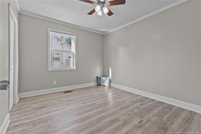 empty room featuring light wood-style floors, ornamental molding, and baseboards