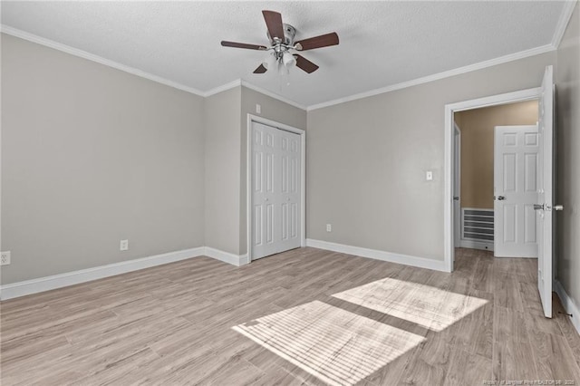 unfurnished bedroom featuring baseboards, crown molding, and light wood finished floors