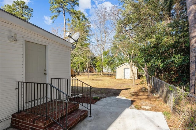 view of yard featuring an outbuilding, a fenced backyard, a patio, and a storage shed