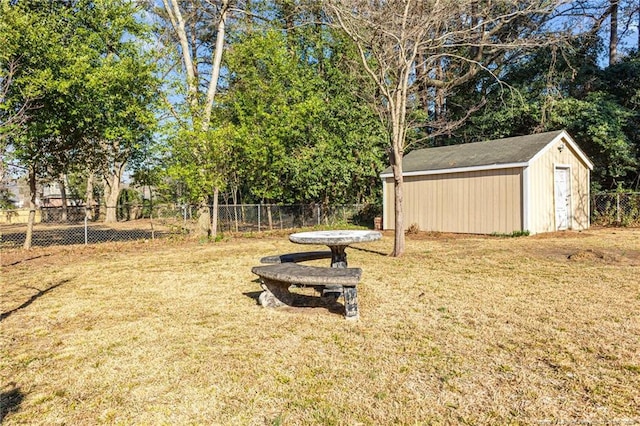 view of yard featuring an outbuilding, a fenced backyard, and a storage unit