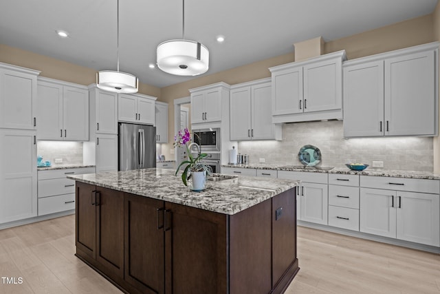 kitchen with stainless steel appliances, light wood-type flooring, and white cabinets