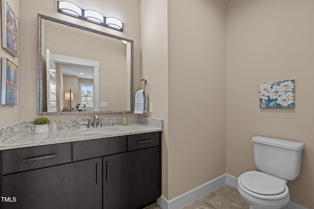 bathroom with tile patterned flooring, toilet, vanity, and baseboards