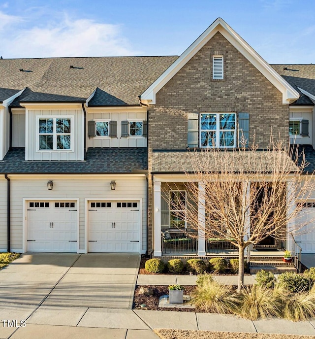 multi unit property featuring board and batten siding, brick siding, driveway, and a shingled roof