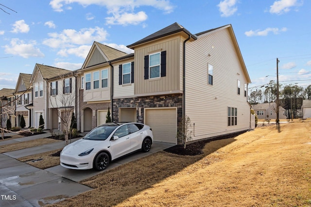 view of front facade with stone siding, a residential view, board and batten siding, concrete driveway, and a garage