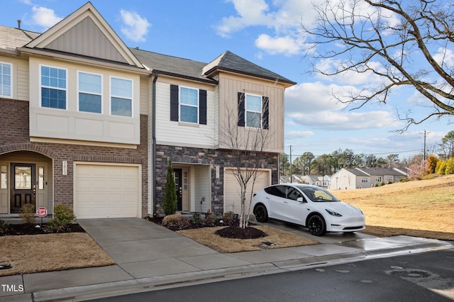 multi unit property featuring brick siding, board and batten siding, a garage, stone siding, and driveway