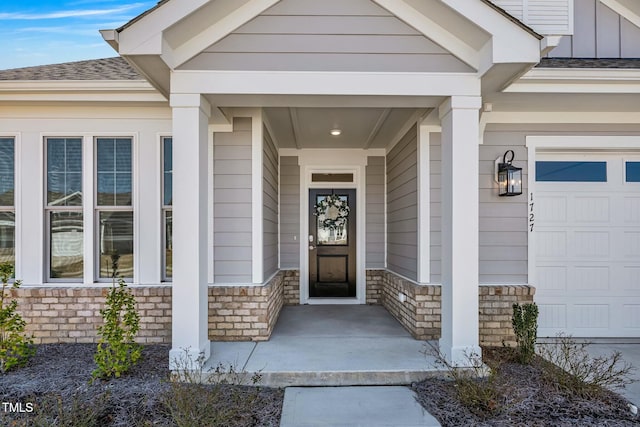 entrance to property featuring stone siding, a shingled roof, and board and batten siding