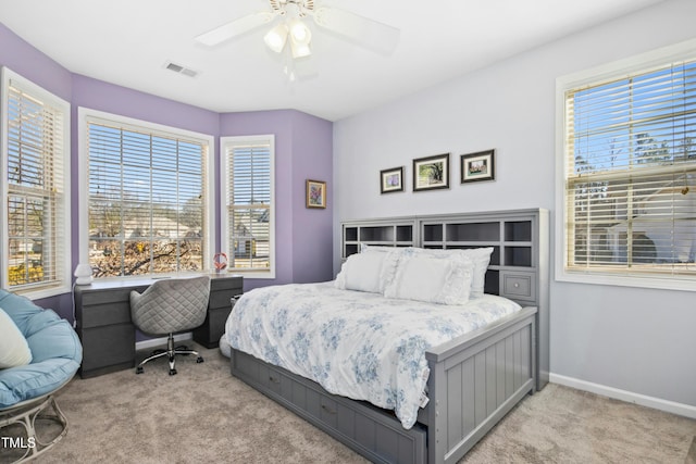 bedroom with light carpet, ceiling fan, visible vents, and baseboards