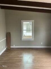 spare room with wood finished floors and baseboards