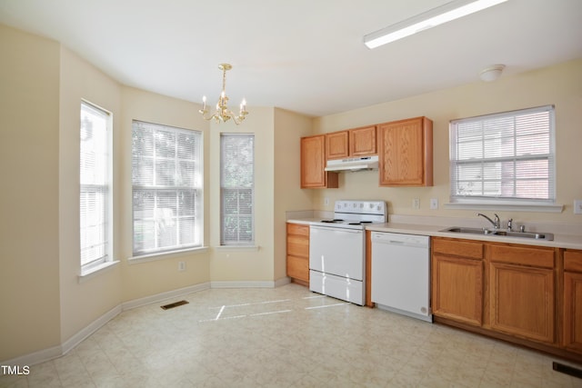 kitchen with light countertops, visible vents, a sink, white appliances, and baseboards