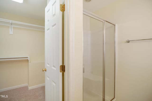 bathroom with a stall shower and baseboards