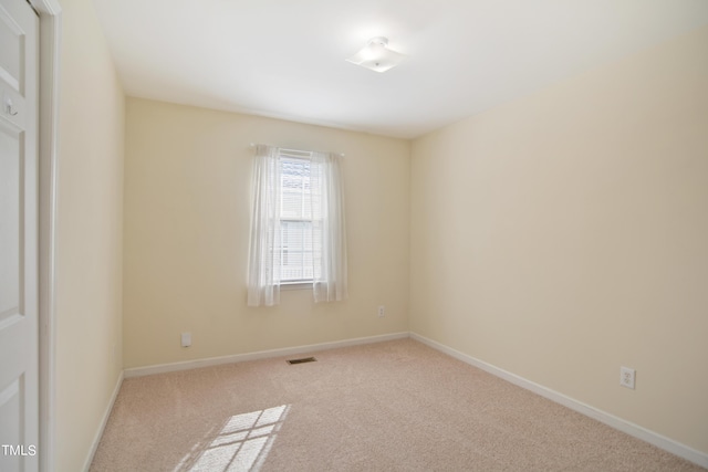 carpeted empty room featuring visible vents and baseboards