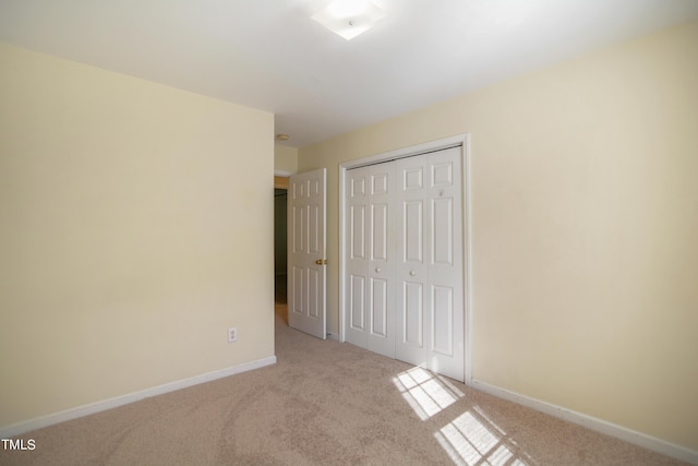 unfurnished bedroom featuring a closet, carpet, and baseboards