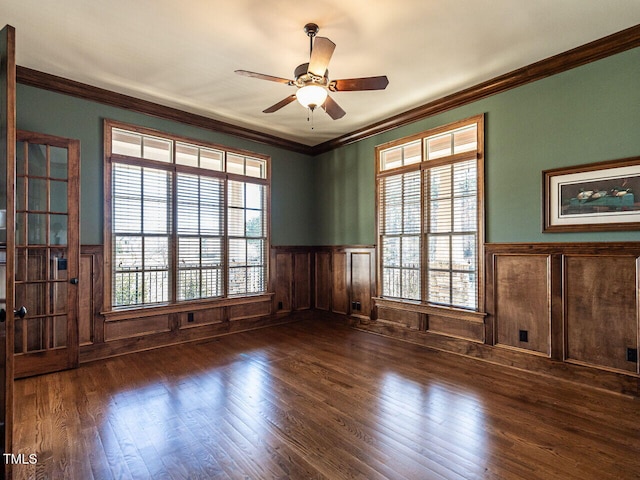 spare room featuring a wainscoted wall, wood finished floors, and crown molding