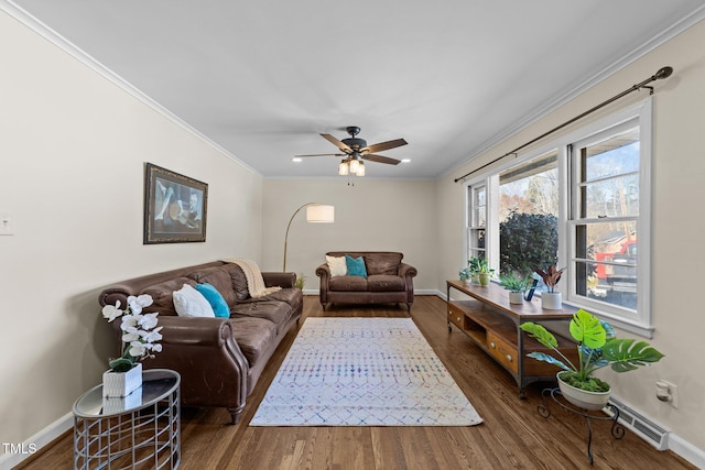 living area with ceiling fan, wood finished floors, visible vents, baseboards, and crown molding